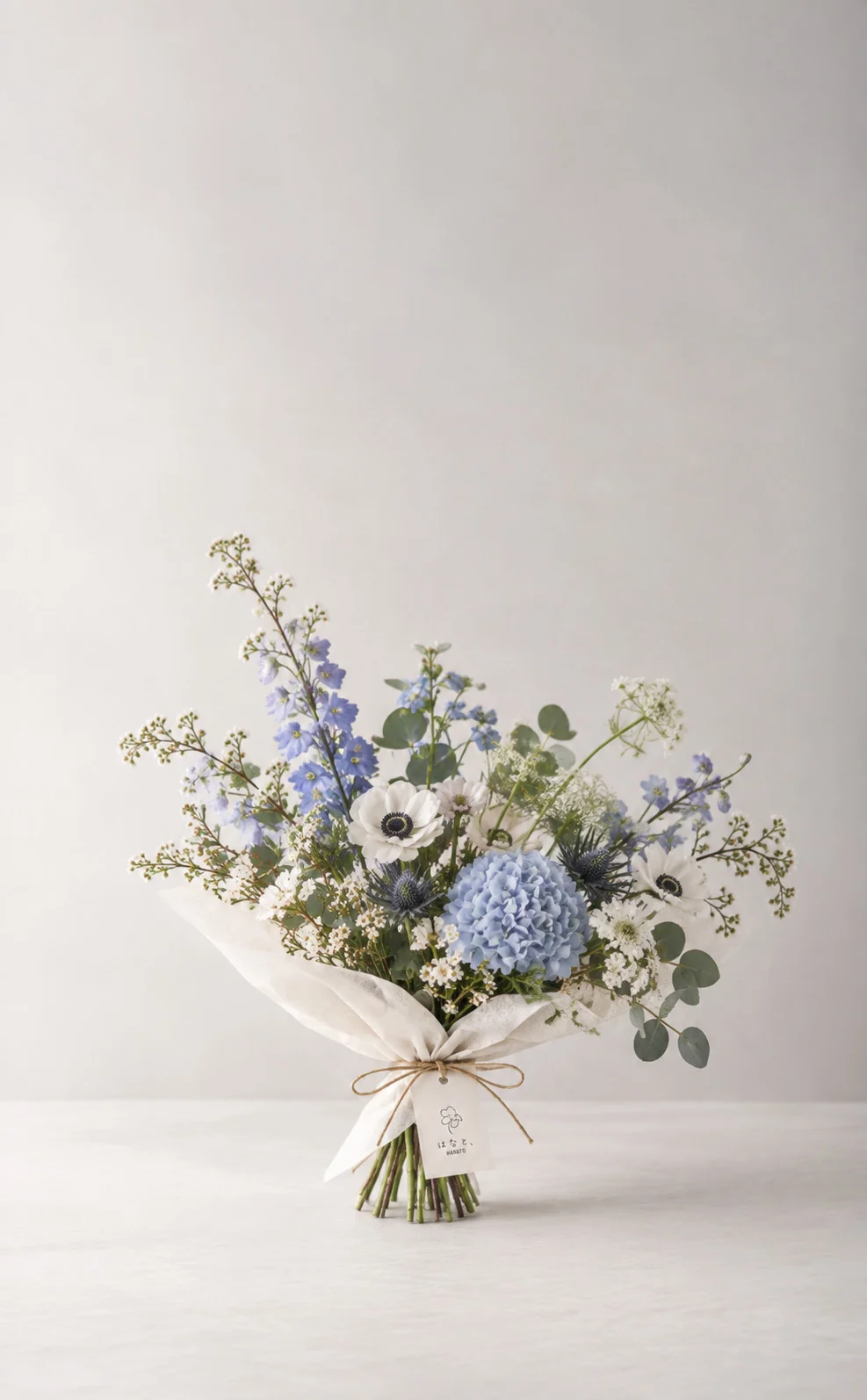 Pale blue hydrangea and tall blue flowers wrapped with white paper